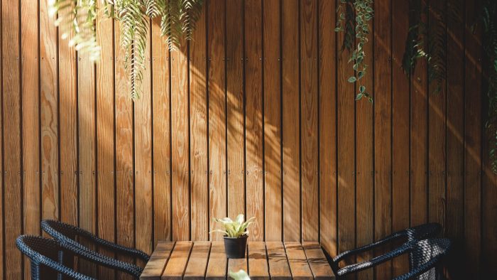 Espace extérieur cosy avec mur en bardage bois vertical et des meubles de jardin
